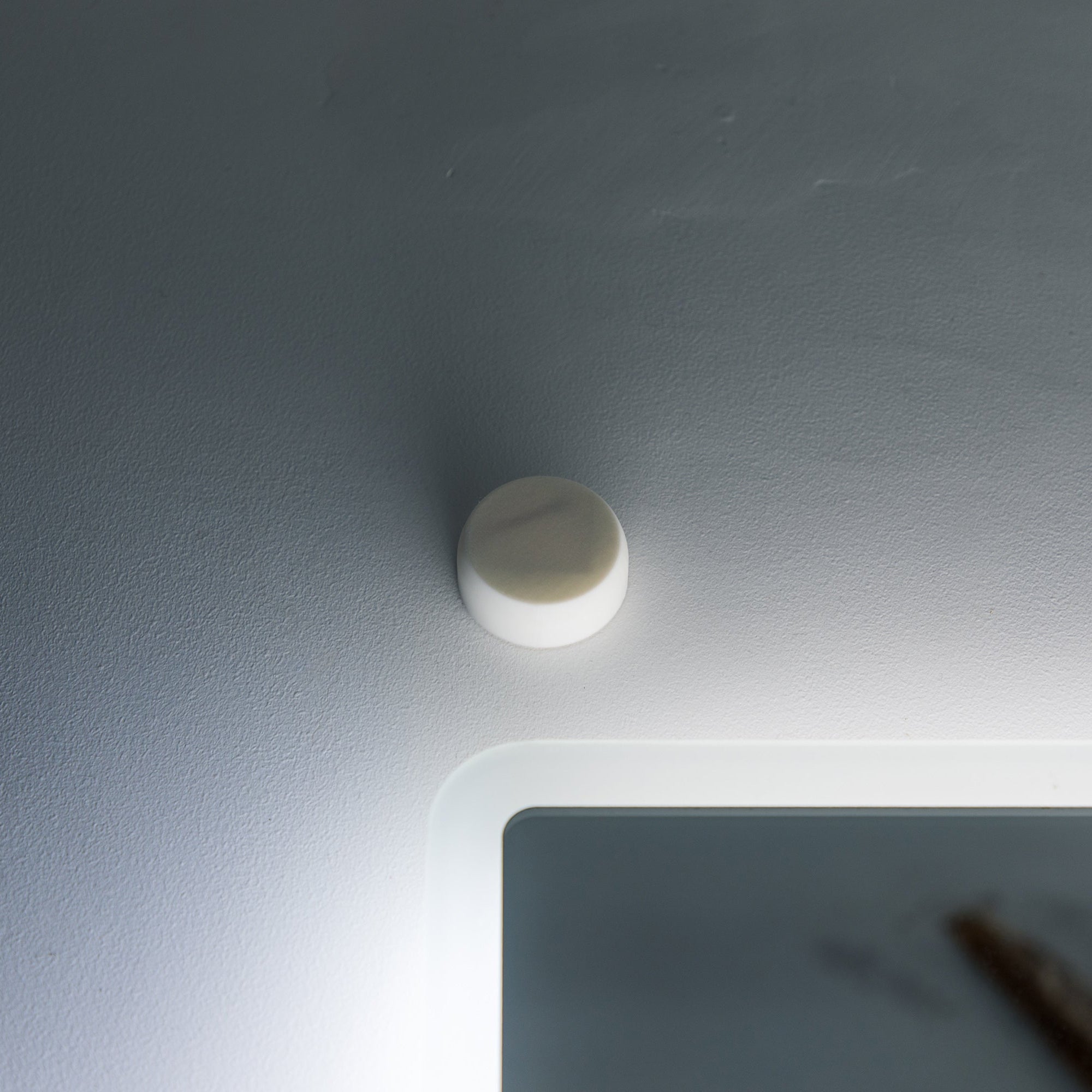 AIRaware on a bathroom wall with a light source creating a shadow.